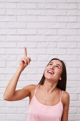 Wall Mural - Mid-length shot of curious brunette pointing out with index fing