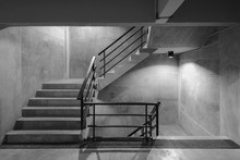 Empty Modern Rough Concrete Stairway With Black Steel Handrail
