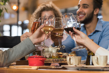 Wall Mural - Young Business People Group Drink Wine Sitting Restaurant Table, Friends Hold Glasses Toasting Smiling Mix Race Men Women