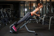 © nazarovsergey - Muscular young woman doing exercises on the simulator in the gym