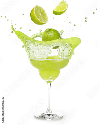 Fotografie, Obraz lime falling into a margarita cocktail splashing isolated on white
