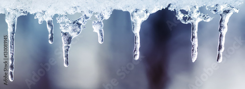 Fotografía lots of shiny cold icicles of clear ice hanging in the bright spring day