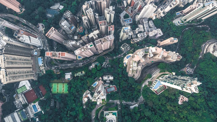 Top view or aerial shot of skyscrapers and green trees in a big city. Hong Kong, China.