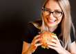 beautiful young, healthy girl holds a tasty big burger with beef