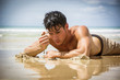 © theartofphoto - Half body shot of a handsome young man laying on a tropical beach in Phuket Island, Thailand, shirtless wearing boxer shorts, showing muscular fit body