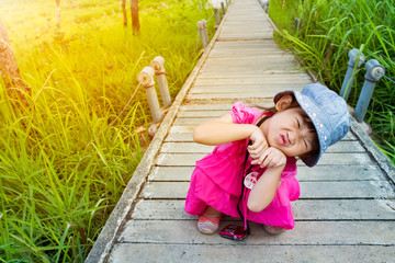 Wall Mural - Happy asian girl relaxing outdoors with bright sunlight at the daytime.