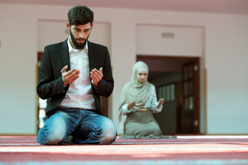 Wall Mural - Muslim man and woman praying in mosque