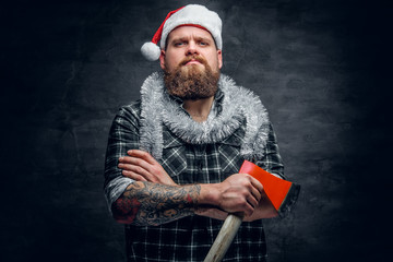 Bearded male in Santa's hat holds the axe.