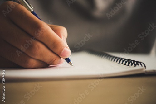 Fotomural Man hand with pen writing on notebook.