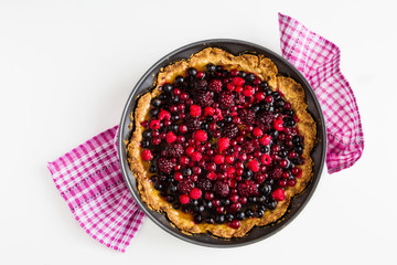 Wall Mural - Open round cake with berries, raspberries, blackberries, red and black currant jelly. Shortbread dough, a layer of cheese. White  table, top view.