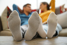 Closeup Of Couple's Feet Laid On Table