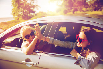 Poster - happy teenage girls or women in car at seaside