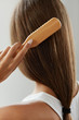 © puhhha - Back View Of Woman With Healthy Long Hair Brushing It With Brush