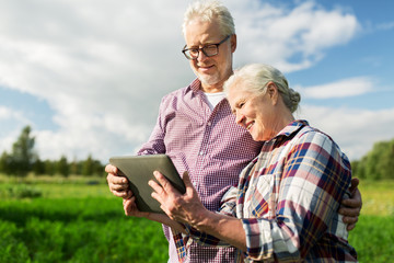 Wall Mural - happy senior couple with tablet pc at summer farm