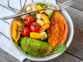 Wall Mural - Salad with grilled vegetables: grilled sweet potatoes, tomatoes, avocados, spinach, tofu, pepper in a white bowl. Perfect for the detox diet or just a healthy meal.