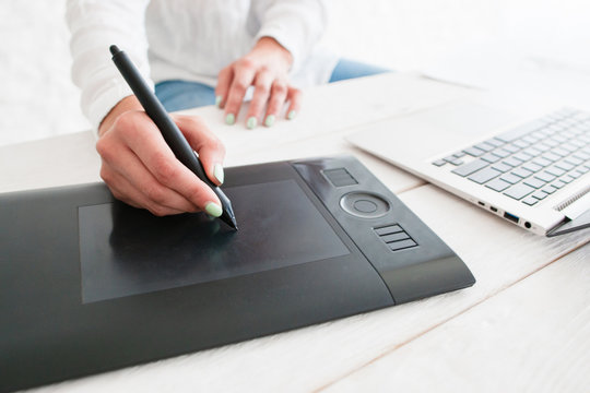 Designer hand work on graphic tablet close-up. Retoucher drawing on special painting device. Art, business, creativity, craft, design, talent, work concept