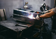 © hedgehog94 - Factory for production of heavy pellet stoves and boilers. Close up shot of manual worker's hand welding some parts.