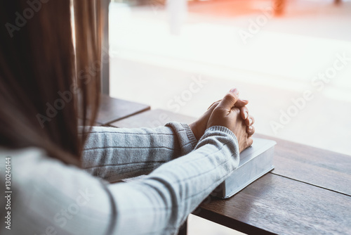 Fotografie, Obraz Girl reading the Bible in the library cafe.