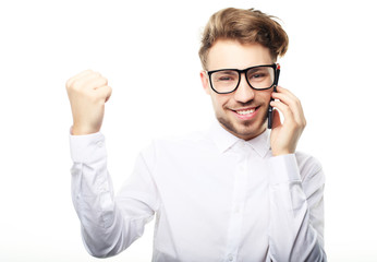 Wall Mural - Happy young man in shirt  gesturing and smiling while talking on