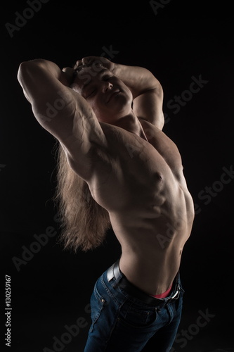 Fényképezés naked torso male bodybuilder athlete with long blond hair in studio on a black b