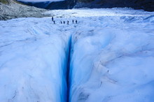 Tourists Hiking Above A Giant Crack On Fox Glacier, Westland Tai Poutini National Park, South Island, New Zealand