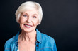 Cheerful elderly woman standign on black background