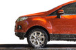 Orange car with white soap on the body in car care shop