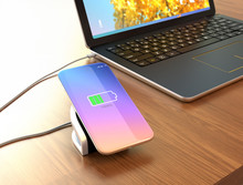 Smartphone On A Wireless Charging Pad. The Pad Connected To A Laptop Computer. 3D Rendering Image.