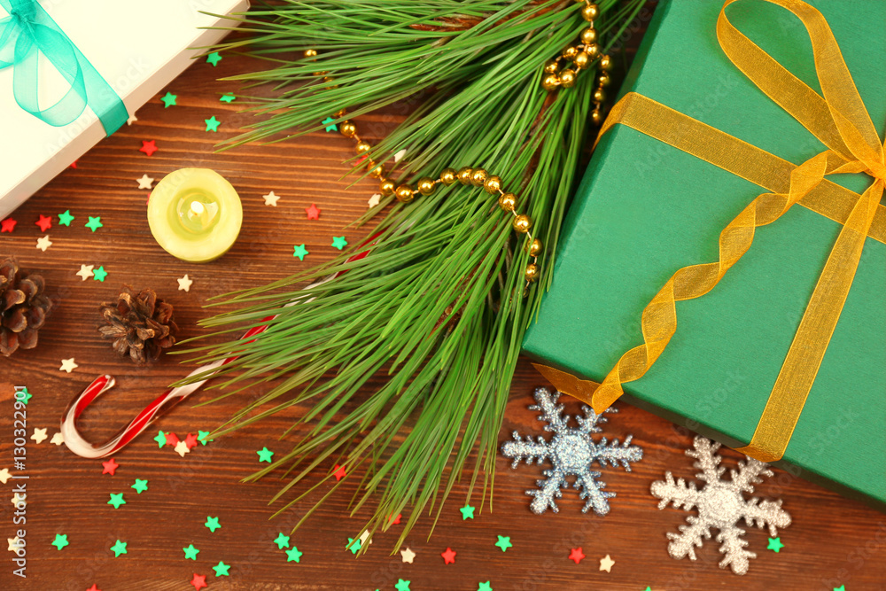 Big Christmas gift with branch and decorations on a wooden board