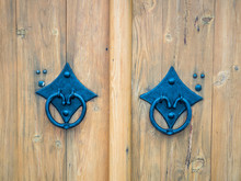 Picture Of The Double Door With Blue Door Handle Close Up. Background Of The Bright Coloured Wooden Gate With Blue Door Handle. Texture Of A Wooden Gate Close Up.