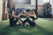 Female Athletes Exercising With Fitness Ball In Gym