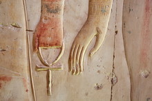 Ankh, An Ancient Egyptian Symbol Of Eternal Life, In Hand Of A God, On The Wall Of The Temple Near Luxor (Thebes), Egypt
