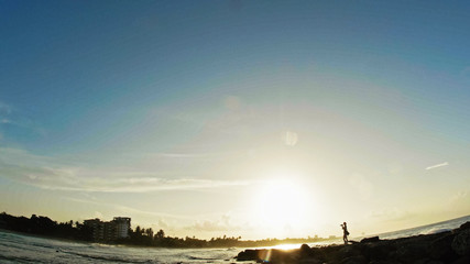 Young woman with red hair photographs sea-life on the caribbean in Dominican Republic, ultra wide angle