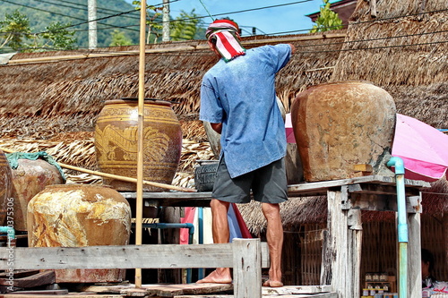 Fotografie, Obraz Villager draw saltwater from the ancient salt well to boil.