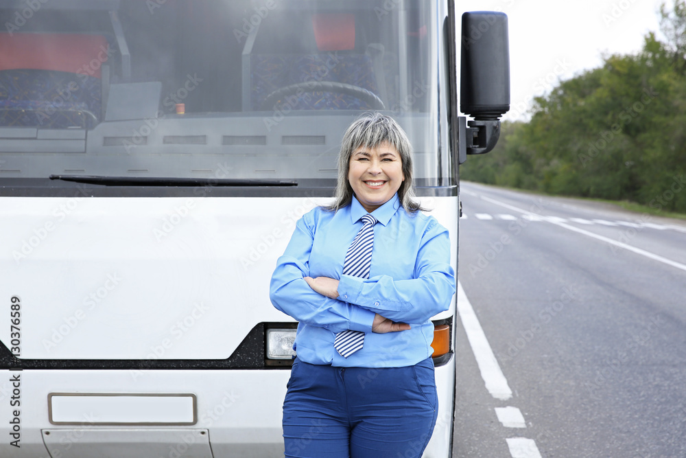 Female driver standing in front of bus