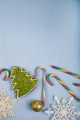 Gingerbread and candy canes on a blue wooden background. Christm