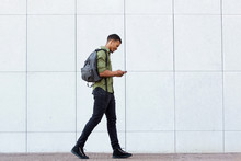 Smiling Man Walking With Backpack Smart Phone And Headphones