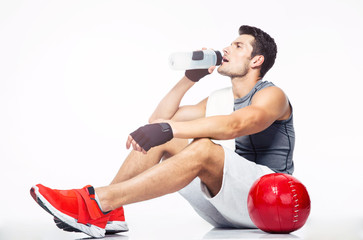 Sticker - Fitness man sitting on the floor and drinking water