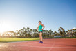 © Dewald - Fit female athlete preparing for a sprint race on a tartan athletic track in a sports stadium