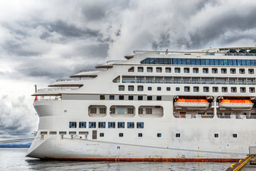 Stern part of white cruise ship at cloudy sky background in Bergen port, Norway.