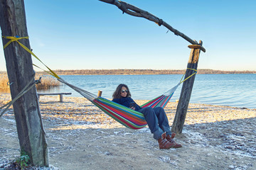 Canvas Print - Frau in einer Hängematte am See - Wintercamping