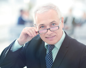 Portrait of mature businessman with  colleagues interacting on b