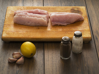 Hake fillets, salt and pepper, lemon and garlic cloves.