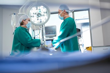 Poster - Surgeons interacting while operating patient