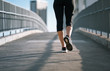 © kieferpix - Closeup of woman runner running on city bridge.