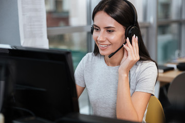 Girl sitting by the computer in headphone