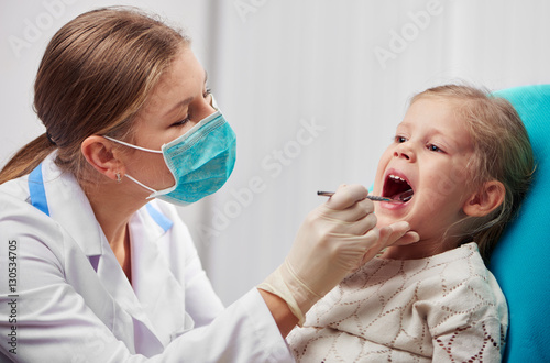 woman-dentist-in-mask-doing-teeth-checkup-of-little-girl-in-dental-room-health-care-and-medicine-concept
