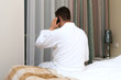 © M-Production - Man in bathrobe with mobile phone in hotel room.