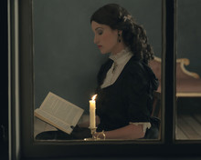 Retro Victorian Girl Reading Book By Candlelight Behind Window.