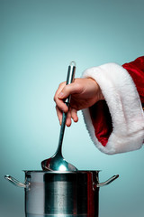 The Santa hand holding a ladle or kitchen spoon